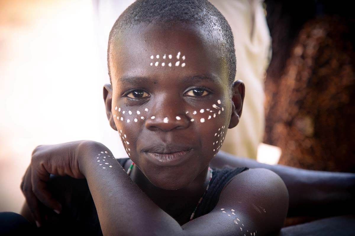 Intergenerational learning is a core part of the process in Tharaka. Elijah Mutwiri is in Grade 9. His face is marked as part of the rite of passage for boys with a paint extracted from a sacred stone known as ira. Photo: Rory Sheldon