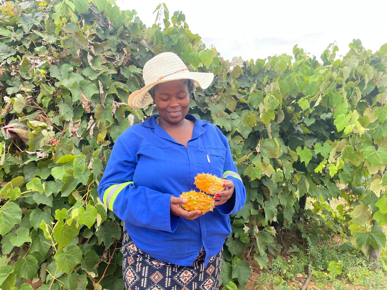 Bongiwe with two spikey African cucumbers from her garden that grow prolifically in the Enkaba area